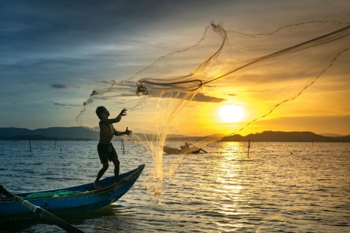 pexels-photo-2131967-1 fisherman throwing fish net on lake